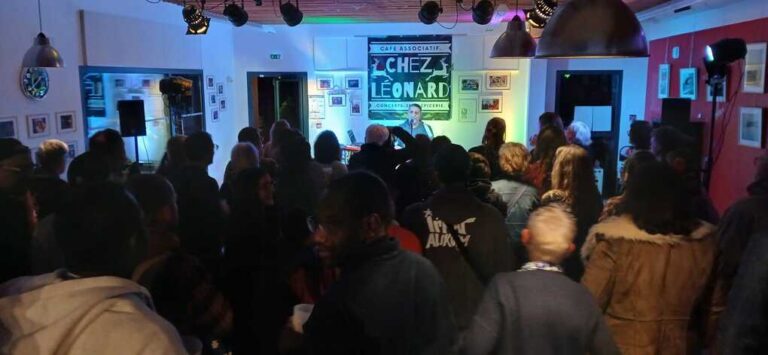 Spectateurs réunis devant une scène avec projection Chez Léonard